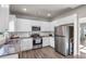 Modern kitchen with white cabinets, granite counters, stainless steel appliances, and hardwood floors at 210 Omega Ct, Dallas, GA 30157