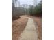 Curving concrete walkway winds through a wooded area at 210 Omega Ct, Dallas, GA 30157