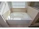 Relaxing bathtub with tile surround and window at 129 Warbler Way, Mcdonough, GA 30253
