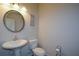 Chic powder room with pedestal sink, toilet and decorative mirror at 129 Warbler Way, Mcdonough, GA 30253
