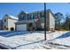 Two-story brick home with a white garage door and snowy lawn at 129 Warbler Way, Mcdonough, GA 30253