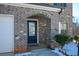 Home's entryway with a dark blue door and brick archway at 129 Warbler Way, Mcdonough, GA 30253