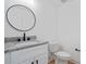 Simple bathroom with single vanity, granite countertop, and round mirror at 2414 Rose Palm Pl, Atlanta, GA 30315