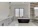 Modern bathroom with soaking tub, marble tile, and walk-in shower at 553 Versailles Dr, Auburn, GA 30011
