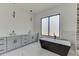 Modern bathroom with soaking tub, marble tile, and walk-in shower at 553 Versailles Dr, Auburn, GA 30011