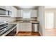 Well-lit kitchen featuring white cabinets, stainless steel appliances, and granite countertops at 3670 Leisure Ln, Atlanta, GA 30349