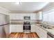 Well-lit kitchen with stainless steel appliances, granite countertops, and white cabinets at 3670 Leisure Ln, Atlanta, GA 30349