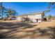 Expansive backyard featuring a deck, patio, and mature trees at 2424 West Rd, Riverdale, GA 30296