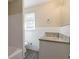 Bathroom featuring tile surround, granite vanity top, and gray wood flooring at 2424 West Rd, Riverdale, GA 30296