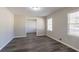 Bright bedroom with neutral walls, two windows, hardwood-style floors and a large closet at 2424 West Rd, Riverdale, GA 30296
