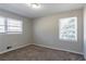 Well-lit bedroom featuring neutral walls, carpet, and two windows bringing in plenty of light at 2424 West Rd, Riverdale, GA 30296