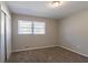 Bedroom featuring neutral walls, carpet, and window with blinds, illuminated by a ceiling light at 2424 West Rd, Riverdale, GA 30296