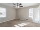 Well-lit bedroom featuring neutral walls, carpet, and a ceiling fan with windows at 2424 West Rd, Riverdale, GA 30296
