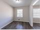Bright bedroom with a large window and neutral walls and gray wood flooring at 2424 West Rd, Riverdale, GA 30296