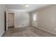 Cozy carpeted bedroom with two doorways, a window, and neutral wall color at 2424 West Rd, Riverdale, GA 30296