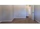 A bedroom with beige walls and carpet, showcasing an open doorway to the hallway at 2424 West Rd, Riverdale, GA 30296