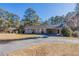 Well-maintained home with a long driveway and a covered carport, surrounded by mature trees at 2424 West Rd, Riverdale, GA 30296