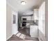 Updated kitchen featuring white cabinets, stainless steel appliances, and wood-look vinyl flooring at 2424 West Rd, Riverdale, GA 30296