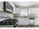 Modern kitchen featuring white cabinets, stainless steel appliances, and granite countertops at 2424 West Rd, Riverdale, GA 30296