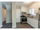 Well-lit kitchen with stainless steel appliances, granite countertops, white cabinets, and new flooring at 2424 West Rd, Riverdale, GA 30296