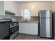 Kitchen with stainless steel appliances, granite countertops, vinyl floors, and white cabinets at 2424 West Rd, Riverdale, GA 30296