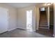 This open living room features luxury vinyl plank flooring and carpeted stairs at 2424 West Rd, Riverdale, GA 30296