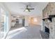Open living room with stone fireplace, ceiling fan, and sliding glass doors at 3887 Mcgill Ln, Decatur, GA 30034