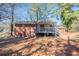 View of the backyard featuring a brick home with a deck and stairs leading to the yard at 5938 Baywood Ln, Riverdale, GA 30296