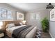 Bright bedroom with neutral tones, modern art, and large windows, staged to showcase a comfortable living space at 5938 Baywood Ln, Riverdale, GA 30296