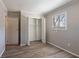 Bedroom showcasing wood-look flooring, a window with blinds, and a closet with bifold doors, creating a cozy retreat at 5938 Baywood Ln, Riverdale, GA 30296