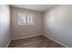 Empty bedroom featuring wood-look floors, neutral paint, and a bright window, offering a clean, bright living space at 5938 Baywood Ln, Riverdale, GA 30296