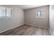 Empty bedroom featuring wood-look flooring, neutral paint, and windows that add natural light to the room at 5938 Baywood Ln, Riverdale, GA 30296