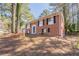 Charming two-story brick home with an attached garage, and a large driveway nestled among mature trees at 5938 Baywood Ln, Riverdale, GA 30296