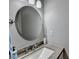 Small bathroom with round mirror and granite countertop at 4942 Payson Se Way, Atlanta, GA 30339