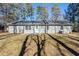 Backyard with a large lawn and mature trees and patio at 920 Navajo Trl, Covington, GA 30016
