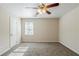 Carpeted bedroom with ceiling fan, closet, and a window allowing for natural light at 920 Navajo Trl, Covington, GA 30016