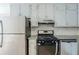 Features in the kitchen include stainless steel appliances, white cabinets, granite countertops, and tile backsplash at 920 Navajo Trl, Covington, GA 30016
