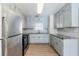 Well-lit kitchen with stainless steel appliances, white cabinets, subway tile backsplash, and granite countertops at 920 Navajo Trl, Covington, GA 30016