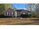 Brick and siding home with dark shutters, groomed landscaping, and an arched window above the entryway at 219 Thorncrest, Stockbridge, GA 30281