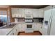 Efficient kitchen boasts white cabinets, modern appliances, and view to kitchen dining area at 219 Thorncrest, Stockbridge, GA 30281