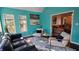 Bright sun room with vibrant turquoise walls, large windows, and a vaulted ceiling perfect for relaxation at 219 Thorncrest, Stockbridge, GA 30281