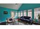 Bright sun room with vibrant turquoise walls, large windows, and a vaulted ceiling perfect for relaxation at 219 Thorncrest, Stockbridge, GA 30281