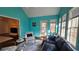 Bright sun room with vibrant turquoise walls, large windows, and a vaulted ceiling perfect for relaxation at 219 Thorncrest, Stockbridge, GA 30281