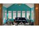 Bright sun room with vibrant turquoise walls, large windows, and a vaulted ceiling perfect for relaxation at 219 Thorncrest, Stockbridge, GA 30281