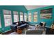 Bright sun room with vibrant turquoise walls, large windows, and a vaulted ceiling perfect for relaxation at 219 Thorncrest, Stockbridge, GA 30281
