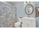 Light blue bathroom with white vanity, toilet, and patterned shower curtain at 3649 Pinehill Cir, Acworth, GA 30101