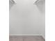 Empty white walk-in closet with carpet floors and hanging rods at 382 Northdale Ct, Lawrenceville, GA 30046
