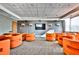Relax in the modern common area with comfortable orange seating, a large screen TV, and stylish decor at 860 Peachtree Ne St # 2506, Atlanta, GA 30308