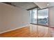 Bright, empty room with hardwood floors and large windows offering stunning views of the city skyline at 860 Peachtree Ne St # 2506, Atlanta, GA 30308