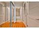 Hallway with hardwood floors, featuring closet with mirrored doors and an adjacent bathroom at 860 Peachtree Ne St # 2506, Atlanta, GA 30308